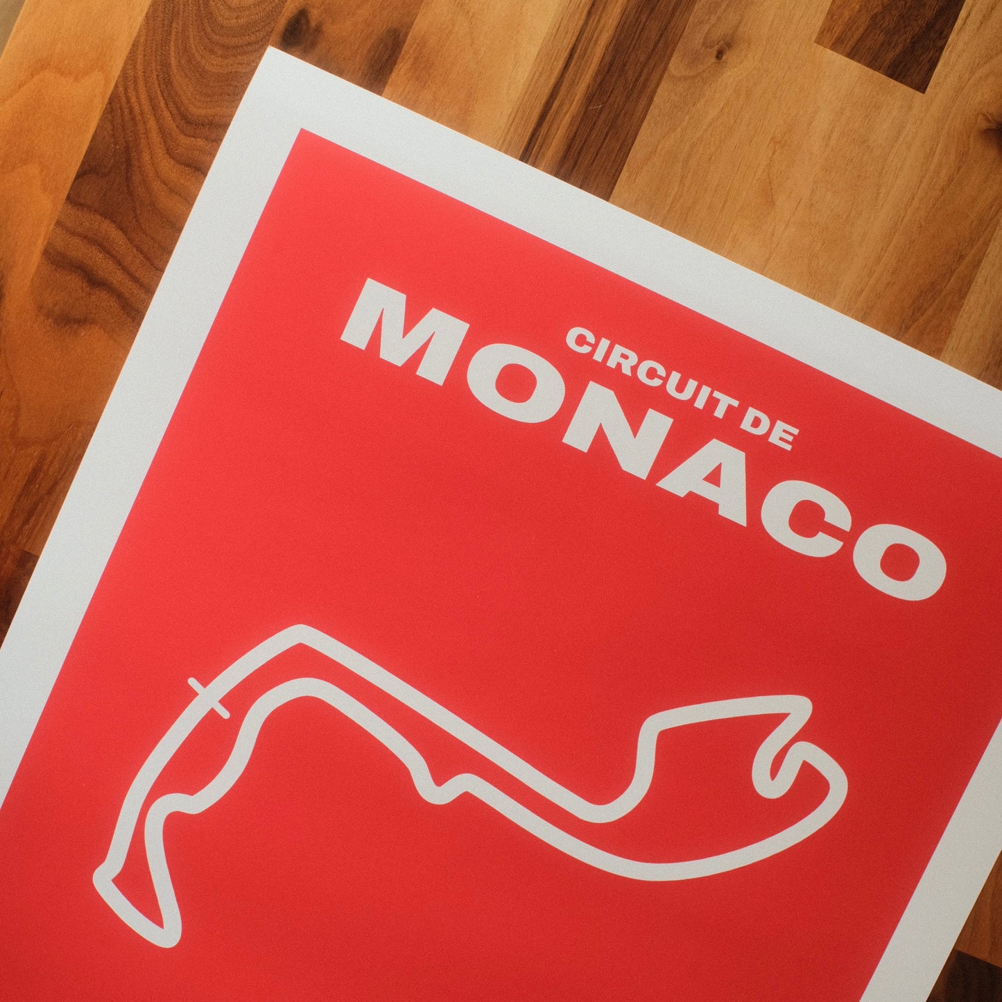 Formula 1 poster of Circuit de Monaco track and grand prix, featuring a bold red design with a minimalist white outline of the famous Formula 1 track layout. Midcentury modern wall art poster.