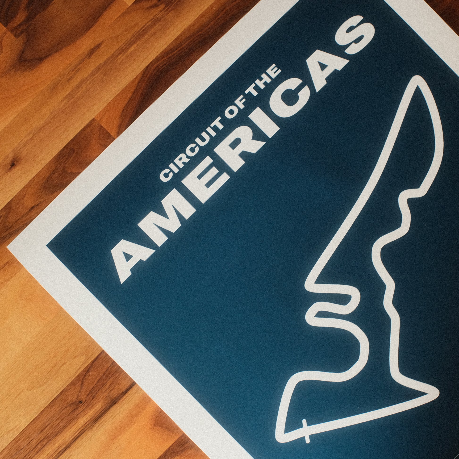 Formula 1 poster of Circuit of the Americas track, showcasing a bold blue background with a minimalist white outline of the iconic F1 track layout. Midcentury modern wall art poster.