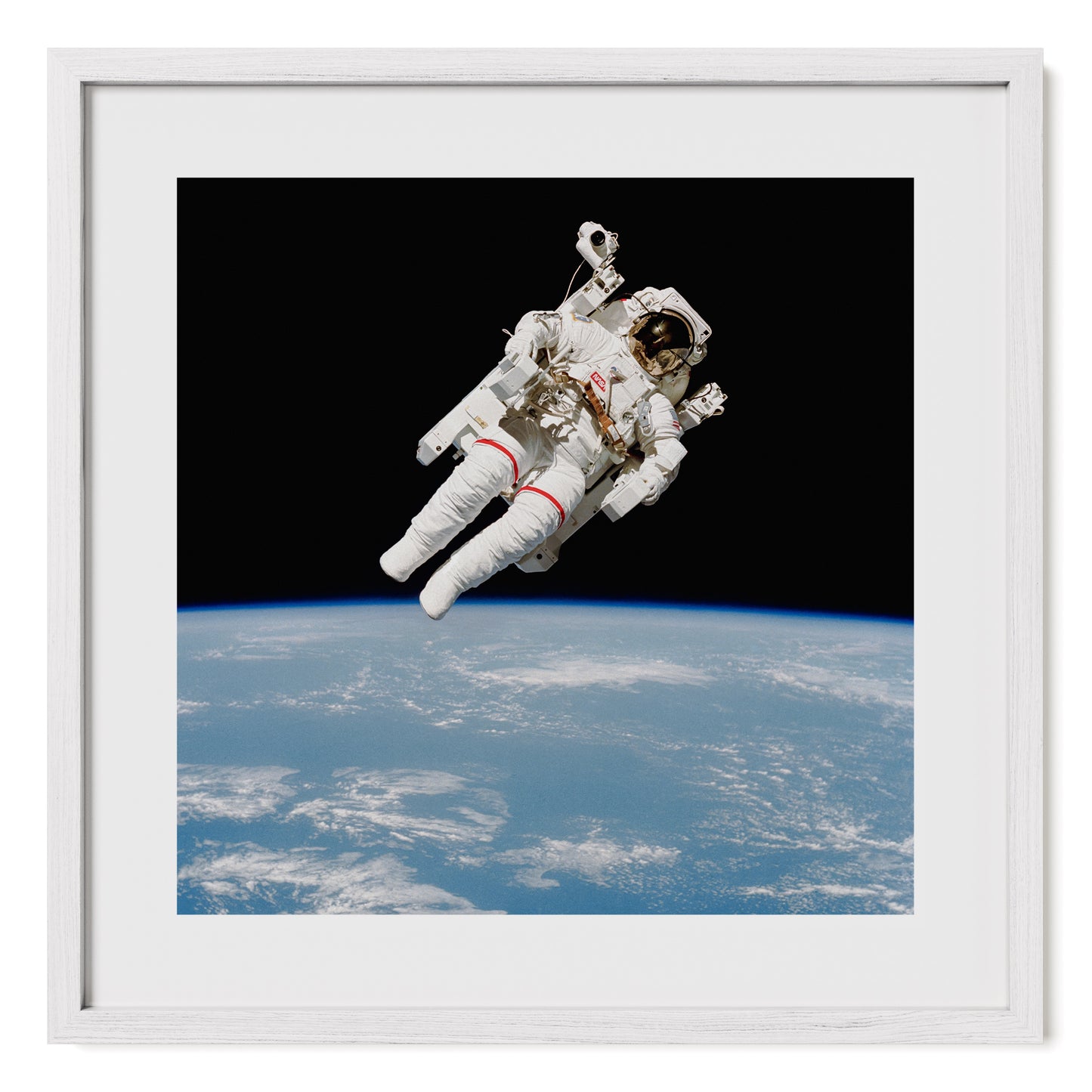 High-resolution fine art print of NASA astronaut Bruce McCandless during a 1984 spacewalk, piloting the Manned Maneuvering Unit (MMU) in space. Photography print framed in oak and tempered glass. Fine art photo print by Airdusk.